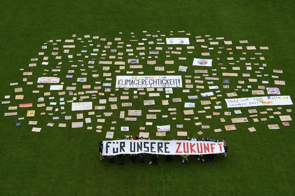 Aktivistinnen und Aktivisten posieren mit ein Banner und Plakaten auf dem Rasen der Sportanlage Schwellenmaetteli, waehrend der Strike for Future, am Freitag 21. Mai 2021, in Bern. Zum ''Str ...