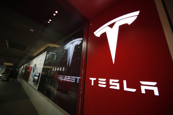 FILE - A sign bearing the company logo outside a Tesla store in Cherry Creek Mall in Denver, Feb. 9, 2019. Tesla is recalling nearly nearly 595,000 vehicles in the U.S., Thursday, April 14, 2022, most ...