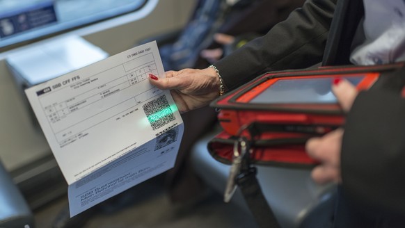 ARCHIV - Train attendant Priska Protmann of Swiss Federal Railways SBB scans a passenger&#039;s electronic ticket in the InterCity train from Zurich to Geneva, Switzerland, on May 29, 2013. --- Preisu ...