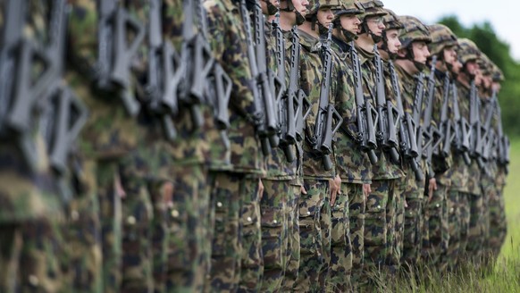 Infantry recruits stand in a row on a green field, pictured on May 17, 2013, in the infantry recruit school of the Swiss army in Colombier, canton of Neuchatel, Switzerland. (KEYSTONE/Christian Beutle ...