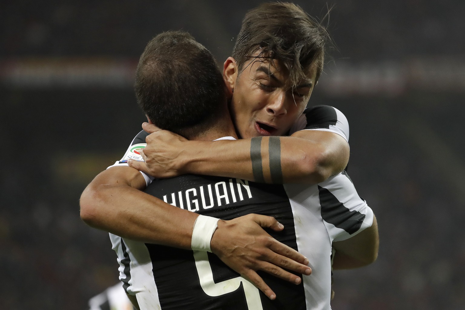 Juventus&#039; Paulo Dybala hugs teammate Gonzalo Higuain who scored his side&#039;s first goal during a Serie A soccer match between AC Milan and Juventus, at the Milan San Siro stadium, Italy, Satur ...