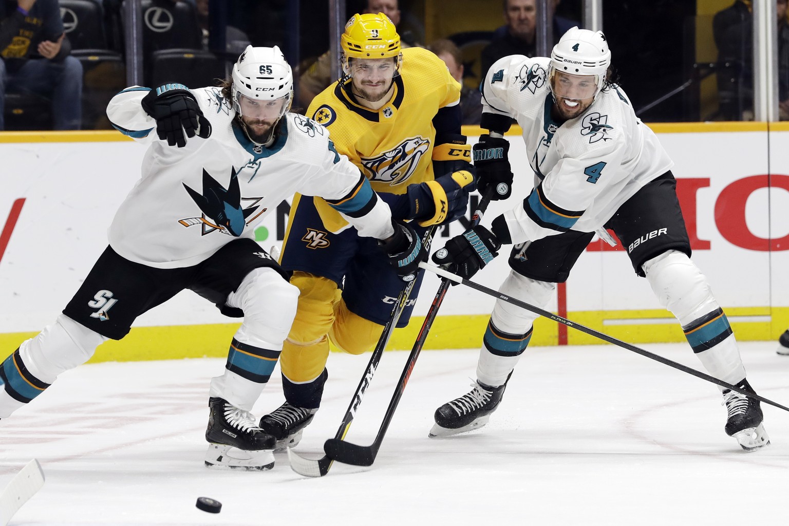 San Jose Sharks defensemen Erik Karlsson (65), of Sweden, and Brenden Dillon (4) cut off Nashville Predators left wing Filip Forsberg (9), of Sweden, during the second period of an NHL hockey game Tue ...