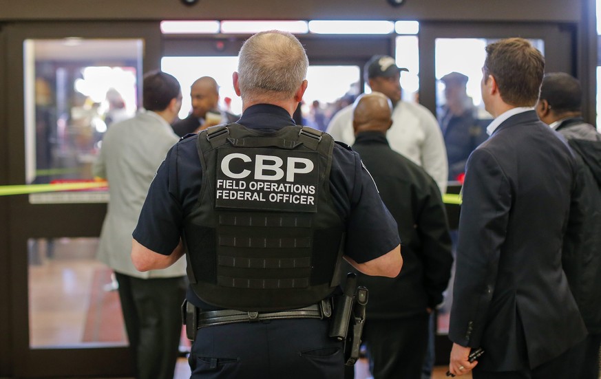 epa05760533 A Customs and Border Protection (CBP) federal officer watches from inside the terminal during a protest at Hartsfield-Jackson Atlanta International Airport after new immigration policies e ...