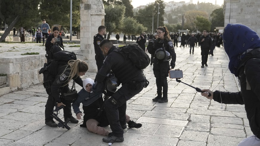 Israeli police arrest a Palestinian woman at the Al-Aqsa Mosque compound following a raid at the site in the Old City of Jerusalem during the Muslim holy month of Ramadan, Wednesday, April 5, 2023. Pa ...