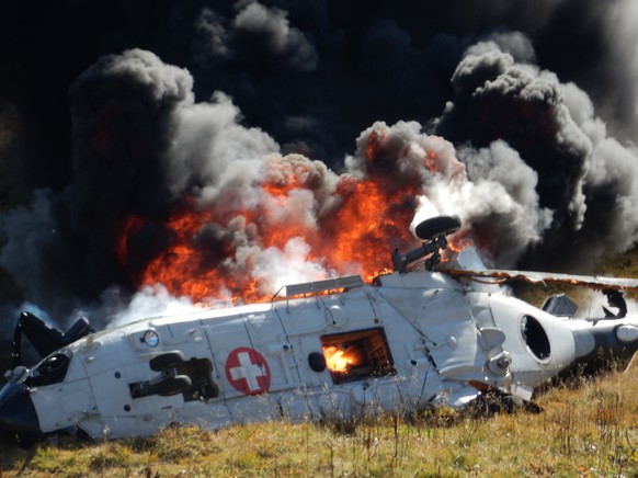 The burning debris oft the crashed Swiss army helicopter in alps near the fort Sasso da Pigna near the Gotthard mountain pass in Airolo, southern Switzerland on Wednesday September 28, 2016. The accid ...