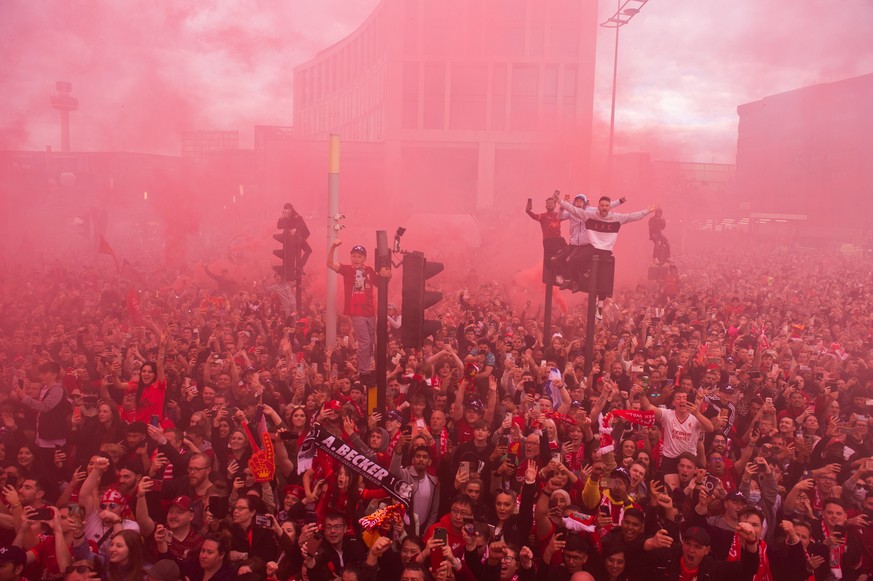 epa09985460 Liverpool supporters greet their team during an open top bus parade where the English Premier League soccer club displays the FA Cup and the Carabao Cup trophies through the streets of Liv ...