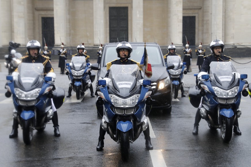 epa06633652 French police on motorcycles escort the coffin of the late Lieutenant Colonel Arnaud Beltrame transported by car during a funeral procession leaving the Pantheon as part of a national trib ...