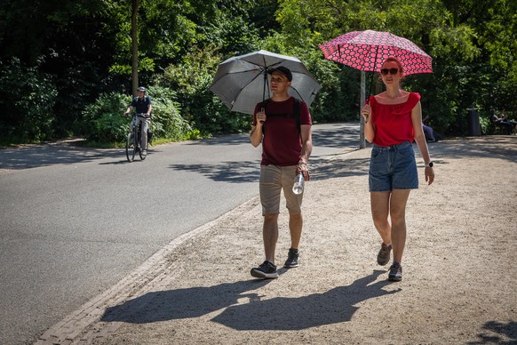 epa13049703 People shelter from the sun under umbrellas in Vondelpark in Amsterdam, the Netherlands, 19 June 2026. Due to the warm weather, the National Heat Plan is in effect nationwide. EPA/DINGENA  ...