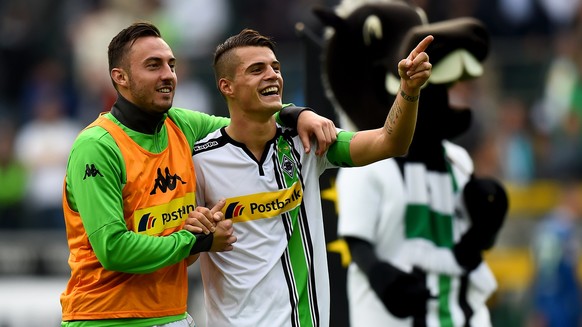 MOENCHENGLADBACH, GERMANY - OCTOBER 03: Granit Xhaka of Moenchengladbach celebrates with team mate Josip Drmic after winning the Bundesliga match between Borussia Moenchengladbach and VfL Wolfsburg at ...