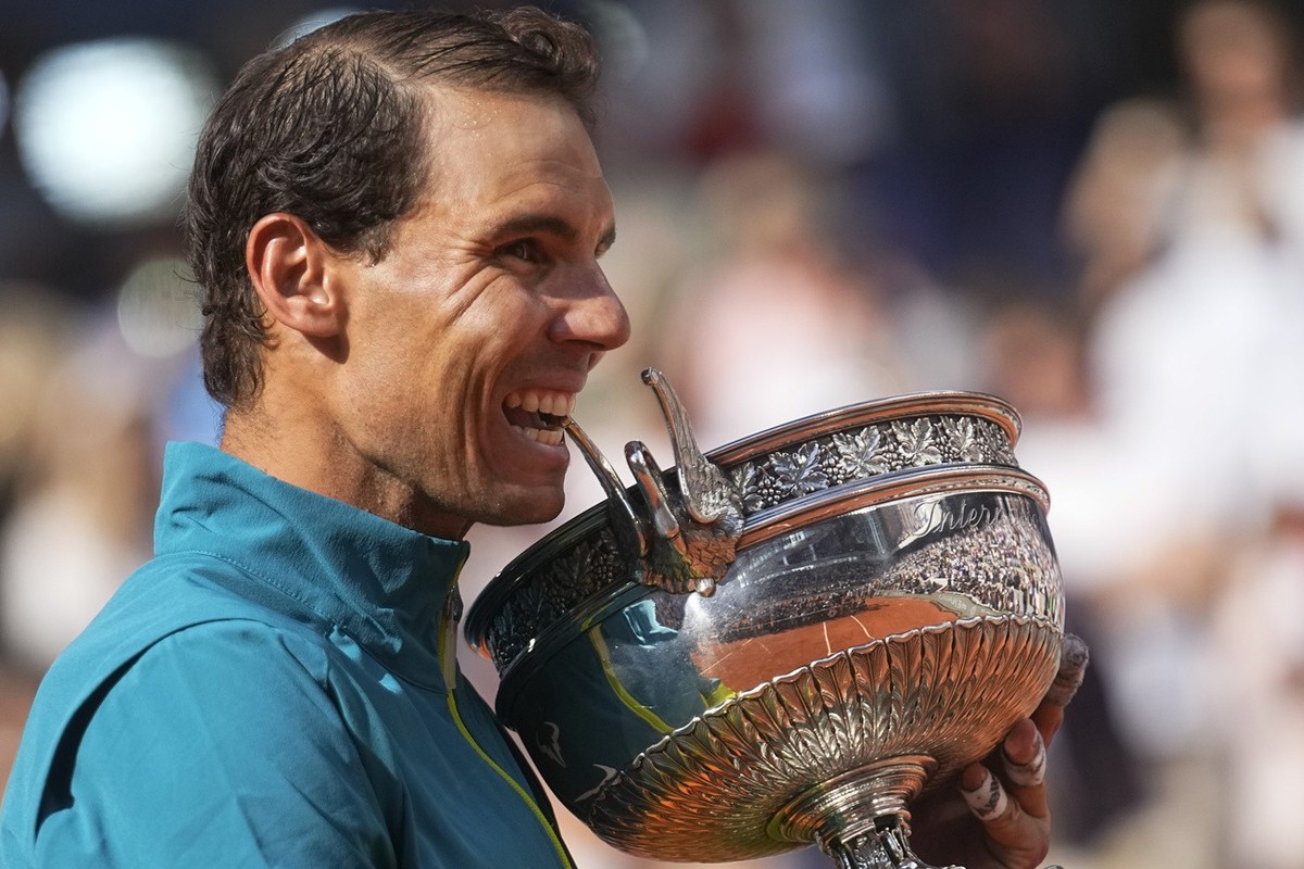 Spain's Rafael Nadal bites the trophy after winning the final match against Norway's Casper Ruud in three sets, 6-3, 6-3, 6-0, at the French Open tennis tournament in Roland Garros stadium i ...