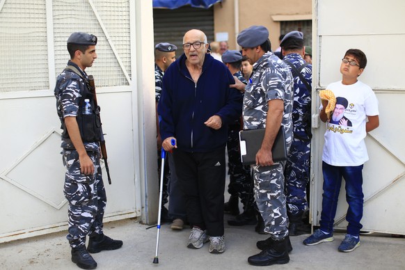 A Lebanese policeman helps an elderly man arrive at a polling station to vote during the Lebanon&#039;s parliamentary elections in a southern suburb of Beirut, Lebanon, Sunday, May 6, 2018. Lebanon&#0 ...