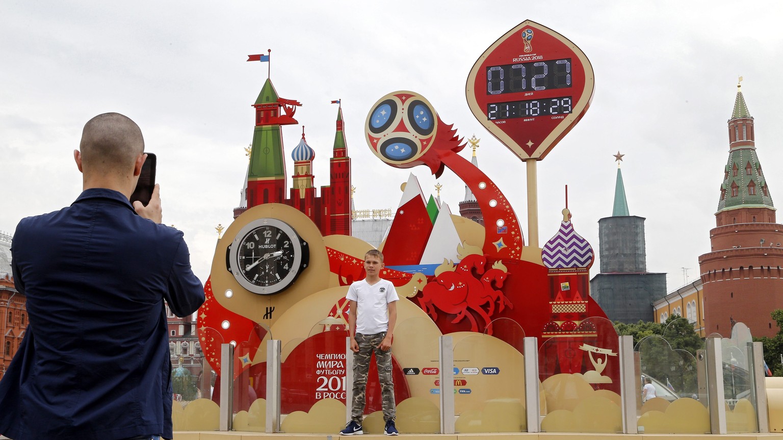 epa05370282 People pose in front of a clock counting down to the first match of the 2018 World Cup at Manezh Square outside the Moscow&#039;s Kremlin in Moscow, Russia, 16 June 2016. Three fans of Rus ...