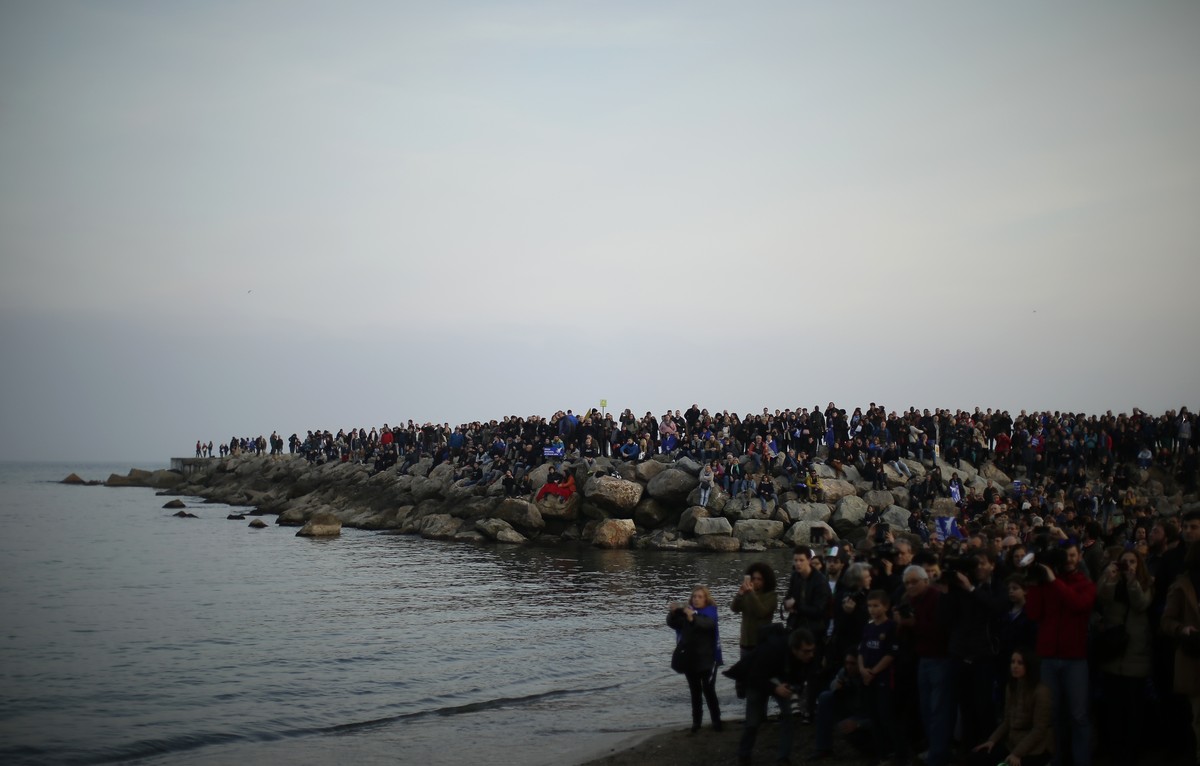Demonstrators stand at the end to the march in front of the mediterranean sea in Barcelona, Spain, Saturday, Feb. 18, 2017. Thousands of people marched in Barcelona to demand Spain's government t ...