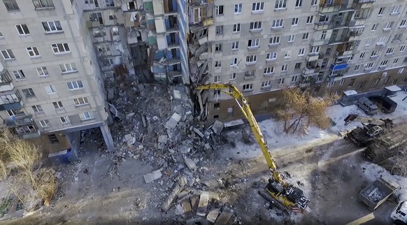 This photo provided by the Russian Emergency Situations Ministry taken from tv footage shows Emergency Situations employees work at the scene of a collapsed section of an apartment building, in Magnit ...