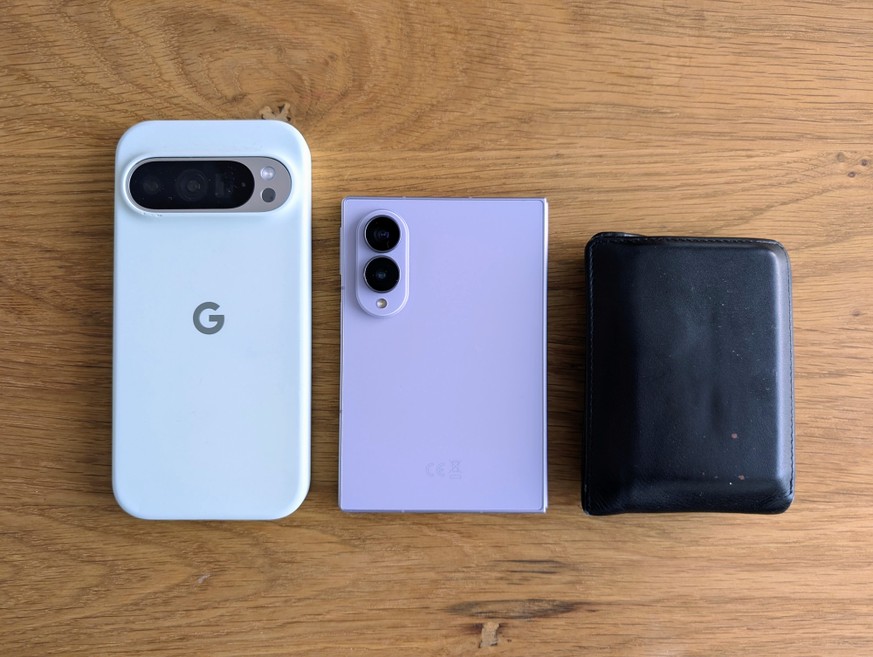 Das Fold 8 umrahmt von einem Google Pixel 9 Pro mit 6,3-Zoll-Display und einem Portemonnaie.