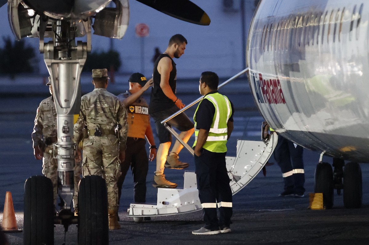 epa11556612 A migrant boards a plane to be deported to Colombia at Albrook 'Marcos A. Gelabert' International Airport in Panama City, Panama, 20 August 2024. The Panamanian government deport ...