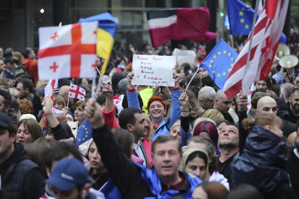 Demonstrators with Georgian national and EU flags rally during an opposition protest against foreign influence bill and celebrating of the Independence Day in the center of in Tbilisi, Georgia, Sunday ...