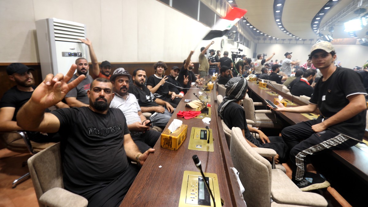 epaselect epa10098537 Supporters of Iraqi Shiite cleric Muqtada al-Sadr, head of the Sadrist movement, gather inside the Iraqi parliament hall after they stormed the 'Green Zone' in central  ...