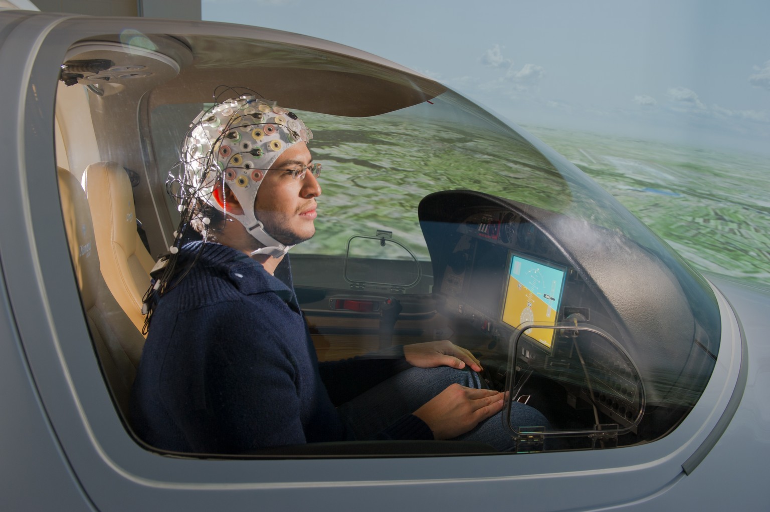 Ein «Testpilot» mit einer EEG-Kappe im Flugsimulator zum hirngesteuerten Fliegen.