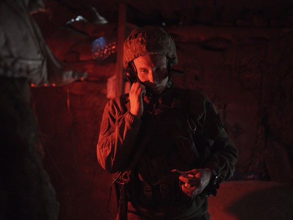 A Ukrainian soldier talks on the phone in a trench at a fighting position on the line of separation from pro-Russian rebels near Donetsk, Ukraine, Monday, May 3, 2021. (AP Photo/Felipe Dana)