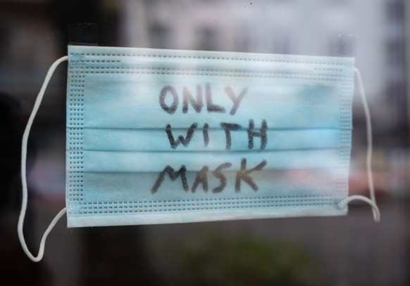 09.11.2021, Berlin: In einem Restaurant in Friedrichshain hängt ein Mund-Nasen-Schutz mit der Aufschrift «Only with Mask». In Berlin wird die Einführung einer flächendeckenden 2G Regelung diskutiert.  ...