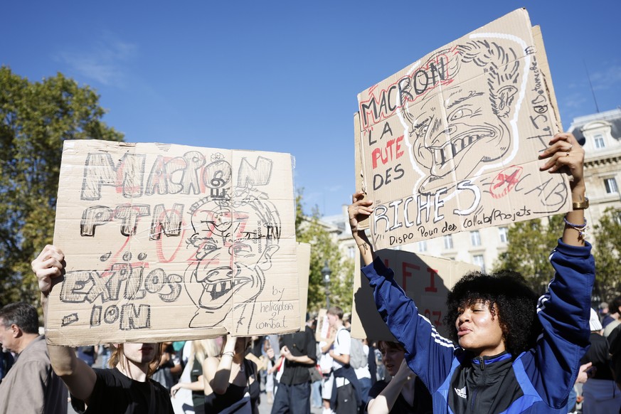 epa13285047 A protester shows a poster depicting caricatures of President Macron during a national day of protests over school conditions by high school students and members of education unions in Par ...