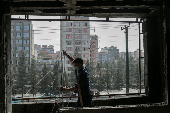 epa12464425 A man clears debris inside a building damaged in alleged Pakistani strike in Kabul, Afghanistan, 19 October 2025. Pakistan and Afghanistan have agreed to an immediate ceasefire after talks ...