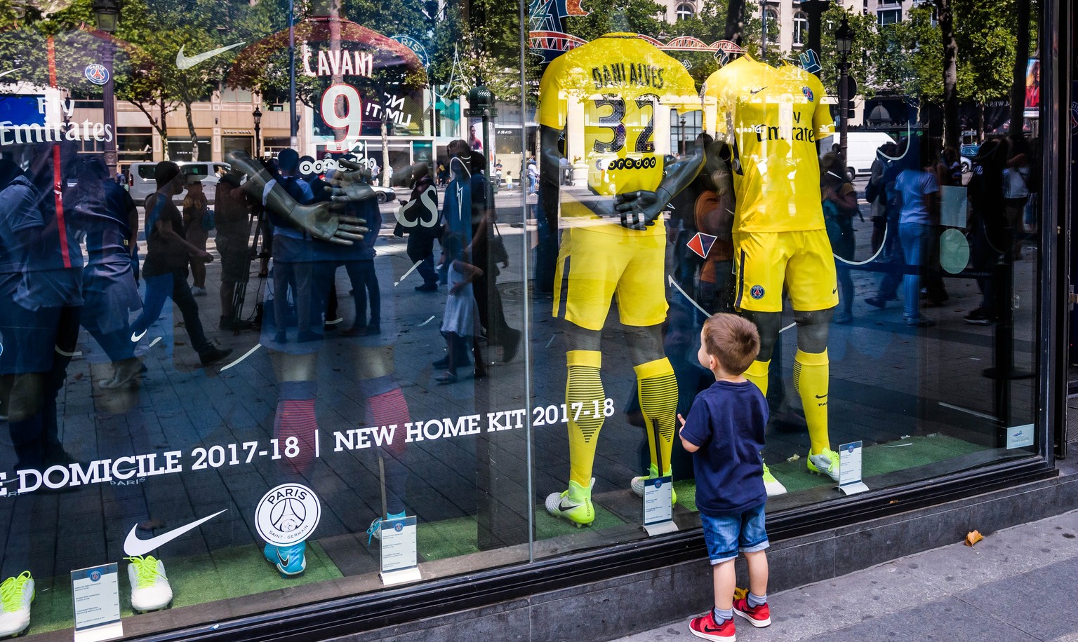 epa06122863 A young boy looks at a display at the official merchandising shop of the French Ligue 1 team Paris Saint-Germain (PSG) at the Champs Elysees in Paris, France, 03 August 2017. Neymar on 02  ...