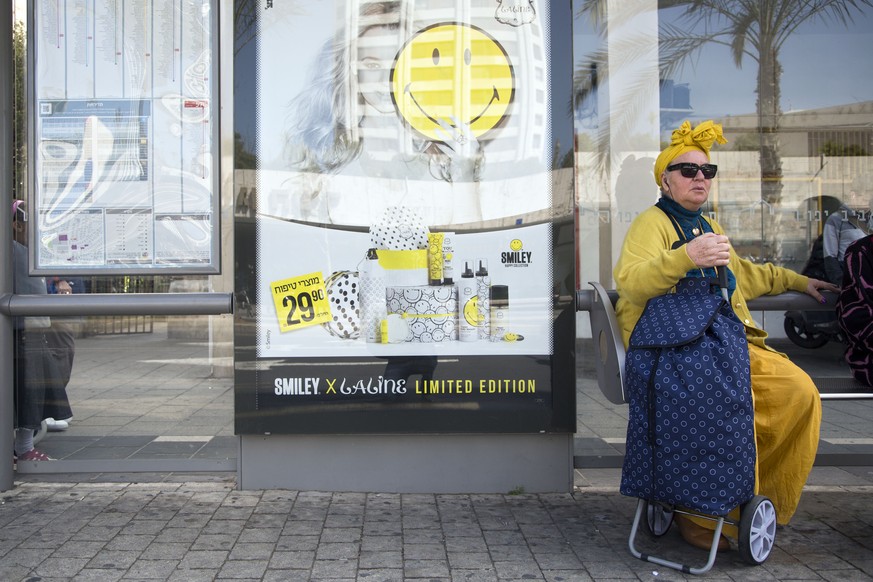 A woman waits for transportation at a bus station in downtown Tel Aviv, Israel, Tuesday, March 24, 2015. (AP Photo/Oded Balilty)