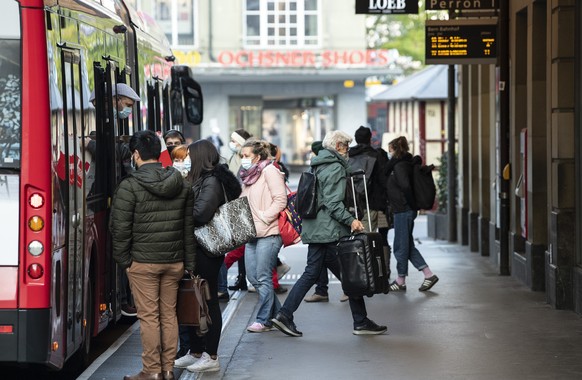 Personen tragen Masken zu den verschaerften Coronaschutzmassnahmen, am Montag, 19. Oktober 2020, bei der Bushaltestelle Loeb in Bern. Die Maskentragpflicht gilt nebst allen oeffentlich zugaenglichen R ...