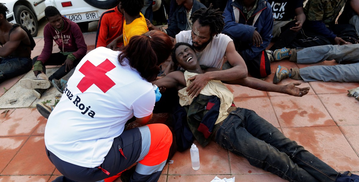A Spanish Red Cross worker aids African migrants after they crossed a border fence between Morocco and Spain's north African enclave of Ceuta October 31, 2016. REUTERS/M. Martin FOR EDITORIAL USE ...