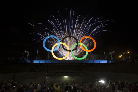Fireworks explode behind the Olympics rings during thier inauguration at the Madureira Park in Rio de Janeiro, Brazil, Wednesday, May 20, 2015. The rings are a gift from the city of London. (AP Photo/Felipe Dana)