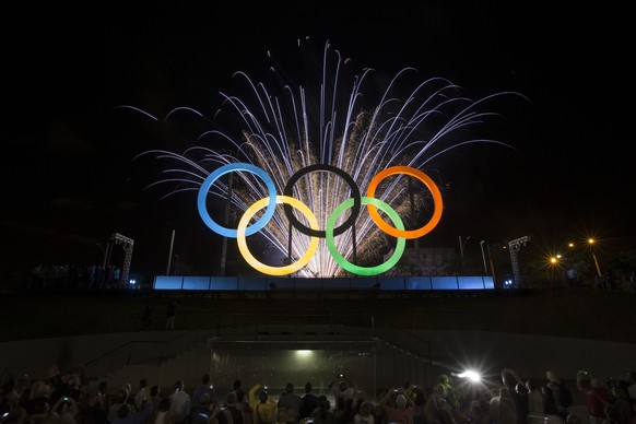 Fireworks explode behind the Olympics rings during thier inauguration at the Madureira Park in Rio de Janeiro, Brazil, Wednesday, May 20, 2015. The rings are a gift from the city of London. (AP Photo/ ...