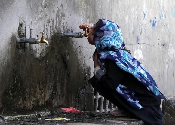 epa08196186 A child drinks water from a donated water pump, in Sanaa, Yemen, 05 February 2020. According to reports, over 17.8 million people in Yemen do not have safe drinking water as the escalating ...