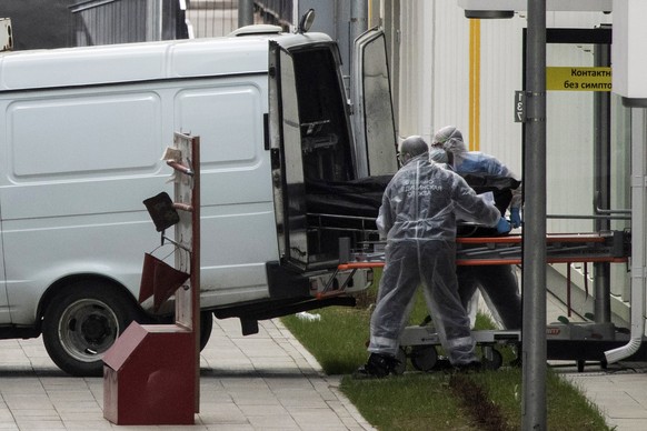 FILE In this file photo taken on Tuesday, April 28, 2020, Medical workers carry a body to a vehicle from the hospital for coronavirus patients in Kommunarka, outside Moscow, Russia. Russia&#039;s upda ...