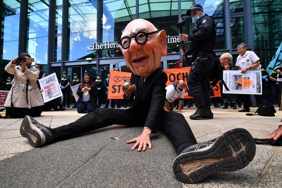 epa09095566 Protesters, including one dressed as Rupert Murdoch, are seen during an Extinction Rebellion environmental protest against Rupert Murdoch and News Corporation in Melbourne, Australia, 25 M ...