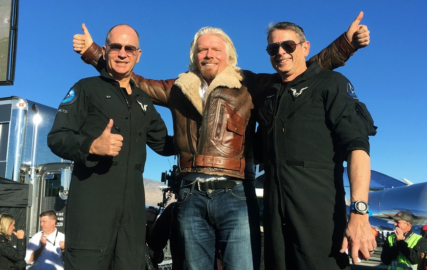 Richard Branson center celebrates with pilots Rick “CJ” Sturckow, left, and Mark “Forger” Stucky, right, after Virgin Galactic’s tourism spaceship climbed more than 50 miles high above California’s Mo ...