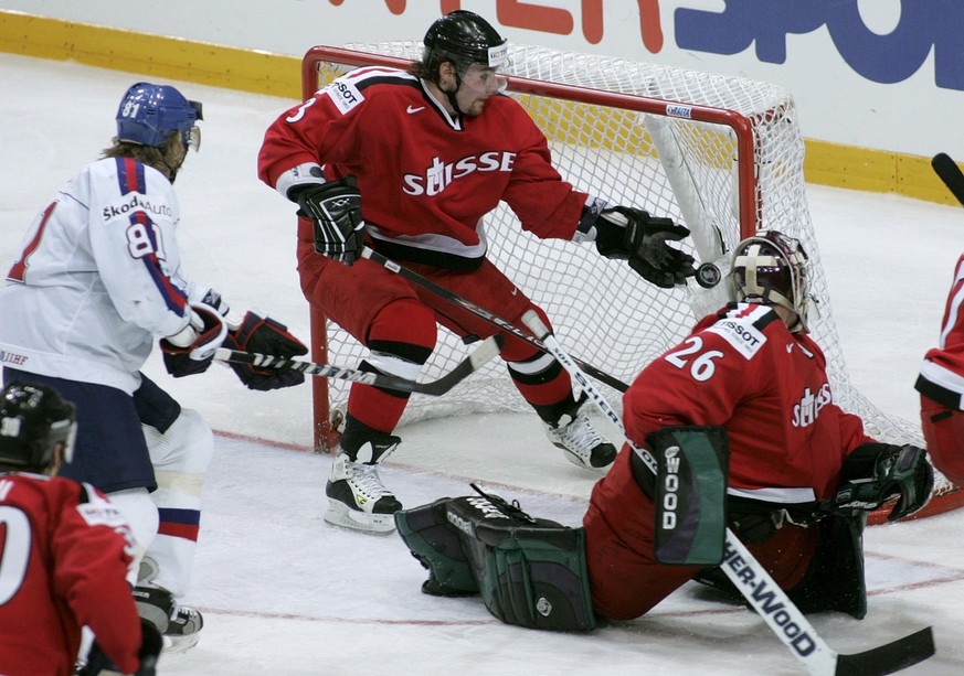 Slovakia&#039;s Pavol Demitra, not in the picture, scored the 3:1 for his team beating Switzerland&#039;s keeper Martin Gerber, right on the ice, and Julien Vauclair, center, during the IIHF Ice Hocke ...