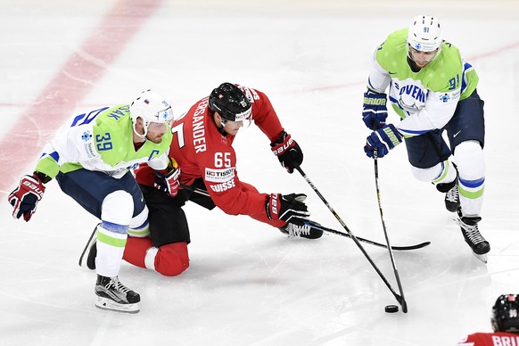 epa05946422 Switzerlandâs Ramon Untersander (C) in action against Sloveniaâs Jan Mursak (L) and Miha Verlic during the 2017 IIHF Ice Hockey World Championship group B preliminary round match betwe ...