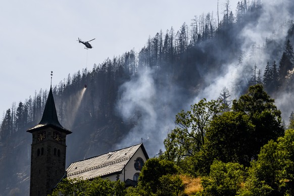 Un helicoptere de la compagnie Air Zermatt, verse de l&#039;eau pour eteindre les foyers dans la foret au-dessus des communes de Bitsch et Ried-Moerel le jeudi 20 juillet 2023 depuis Moerel Filet. Six ...