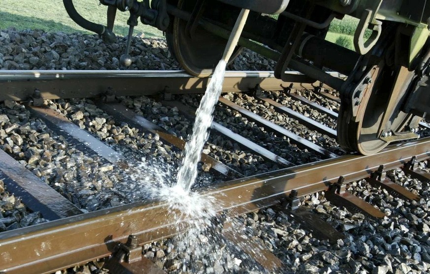 Ein Wagen der SBB kuehlt am Dienstag, 5. August 2003 auf der SBB-Linie Luzern-Zuerich bei Rotkreuz das einspurige Bahngleis mit kuehlendem Wasser. Die grosse Hitze hat am fruehen Dienstagnachmittag da ...