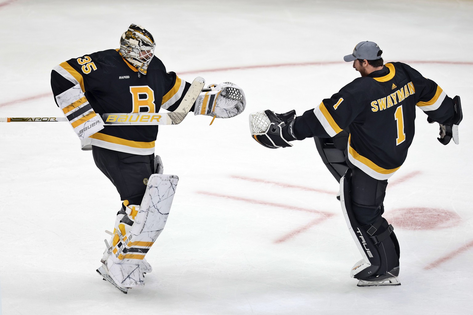 Boston Bruins&#039; Linus Ullmark (35) and Jeremy Swayman celebrate after the Bruins defeated the Minnesota Wild in overtime in an NHL hockey game, Saturday, Oct. 22, 2022, in Boston. (AP Photo/Michae ...