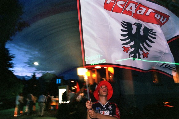 PROJEKT SCHWEIZ - FUSSBALLFANS - Ein junger Fan des ATF schwenkt am Sonntag, 26. April 2003, nach dem Heimspiel &quot;seines&quot; FC Aarau gegen den FC St. Gallen eine grosse Fahne. Er tut dies vor e ...