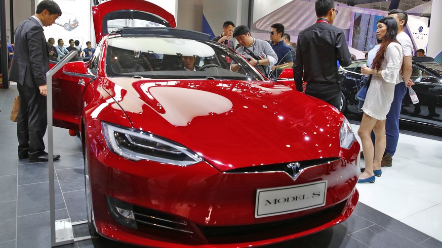 epa07295009 (FILE) - People look at a Tesla model S electric car on display at the Auto China 2016 motor show in Beijing, China, 26 April 2016 (reissued 18 January 2019). Tesla has issued a recall of ...