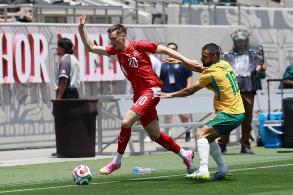 Switzerland's Michel Aebischer, left, and Australia's Aziz Behich in action during a friendly soccer match between Switzerland and Australia at the Snapdragon Stadium in San Diego, Californi ...