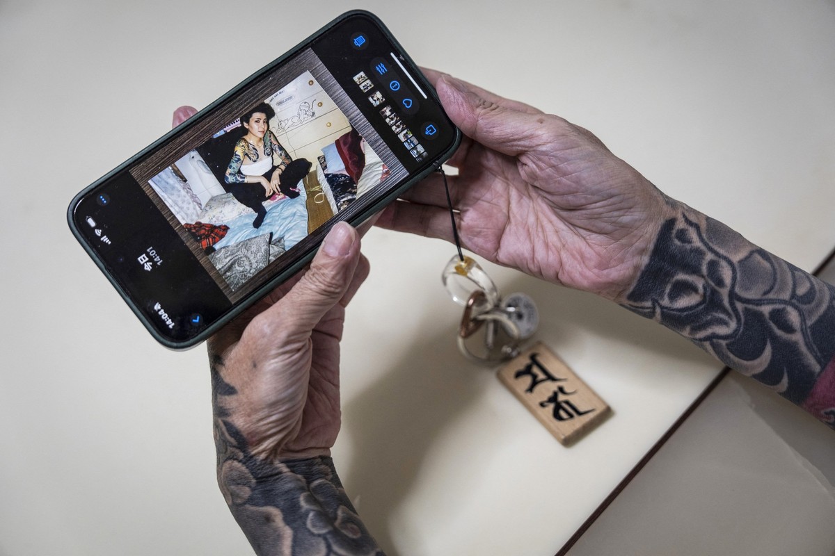 In this photograph taken on September 28, 2025, retired yakuza Mako Nishimura shows a picture of her younger self when she was a part of the underworld, during an interview with AFP at her residence i ...