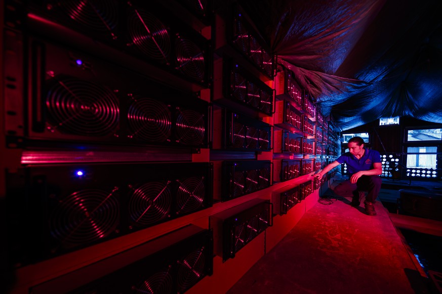 Alpine Mining co founder Theo Martinet performs routine equipment controls on computers in a cryptocurrency mine in the small alpine village of Gondo, Switzerland, Monday, May 7, 2018. The village for ...