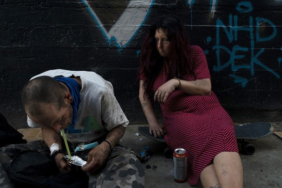 Jenn Bennett, who is high on fentanyl, sits on her skateboard with a visible black eye as her boyfriend, Jesse Williams, smokes the drug in Los Angeles, Tuesday, August 9, 2022. Use of fentanyl, a potent…