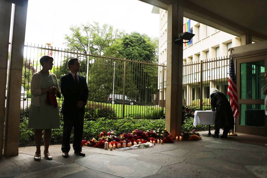 Suzi Levine mit ihrem Ehemann Eric LeVine beim Eingang der US-Botschaft in Bern. Im Hintergrund die Pride-Fahne und die US-Fahne auf Halbmast (13.06.2016).