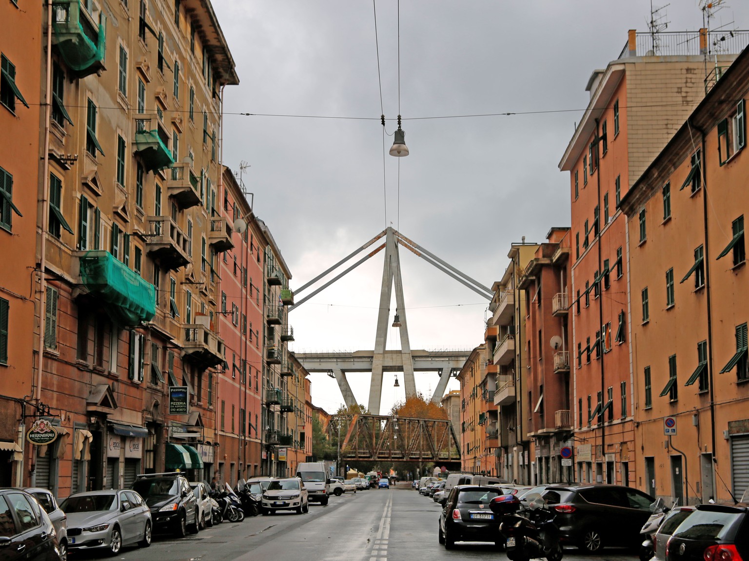 Die Via Fillak im Stadtteil Certosa im Nordwesten von Genua. Im Hintergrund ragt das Skelett der Morandi-Brücke in den Himmel.&nbsp;